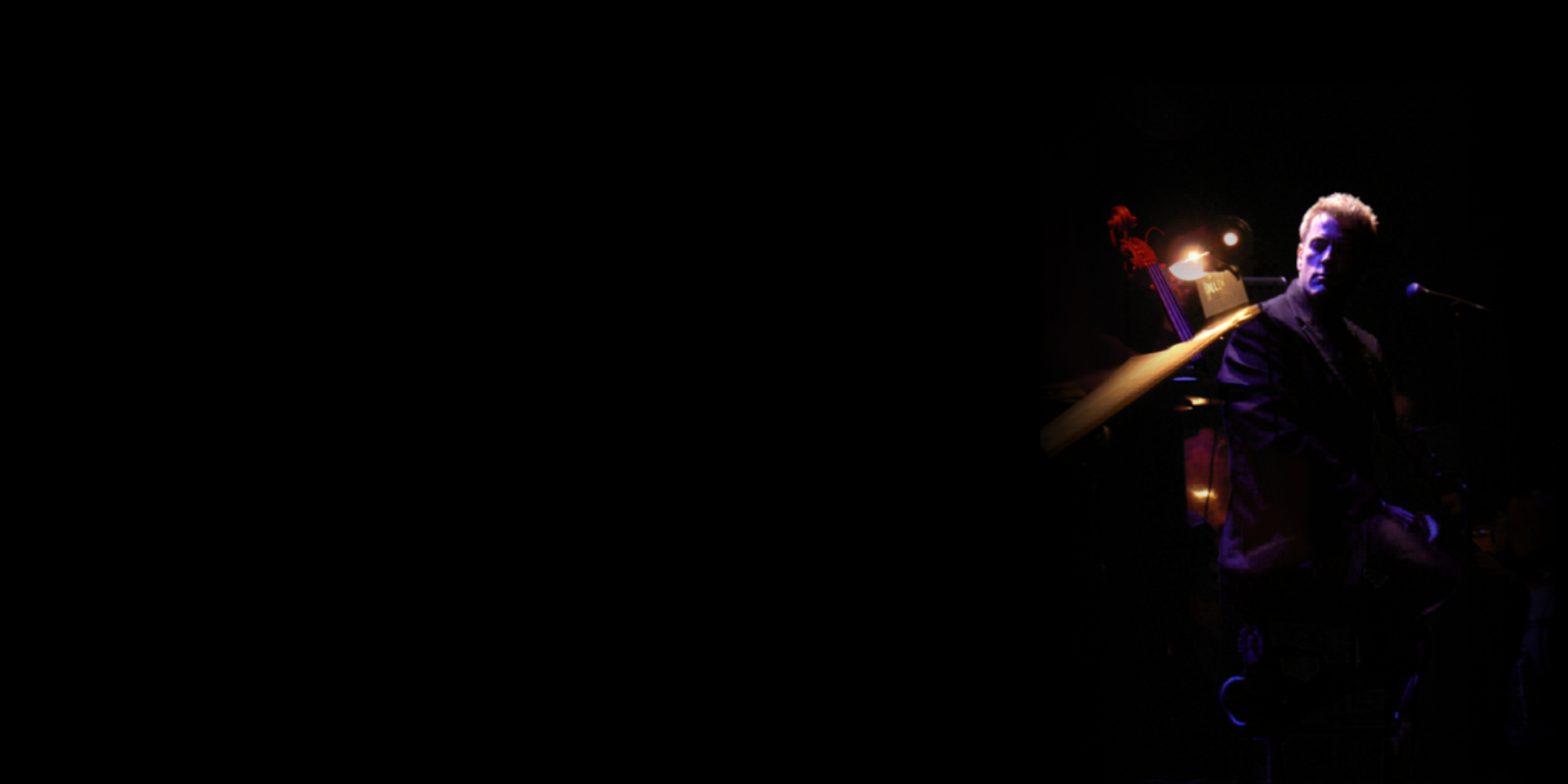 Russ Lorenson onstage under colored lighting.